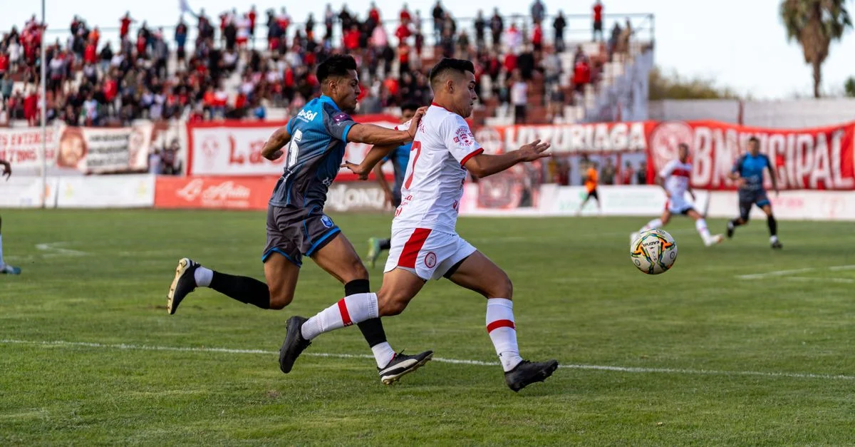 Toma de acción dinámica de dos futbolistas compitiendo ferozmente durante un partido al aire libre.