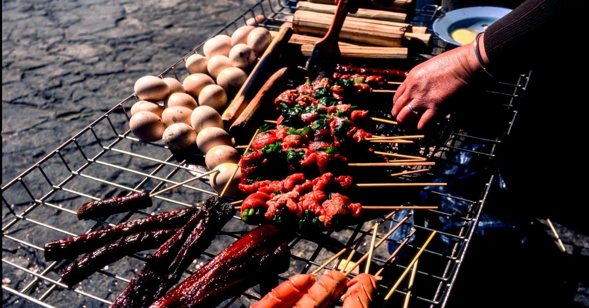 Deliciosa comida callejera a la parrilla con brochetas y huevos en Hà Giang, Vietnam al aire libre.