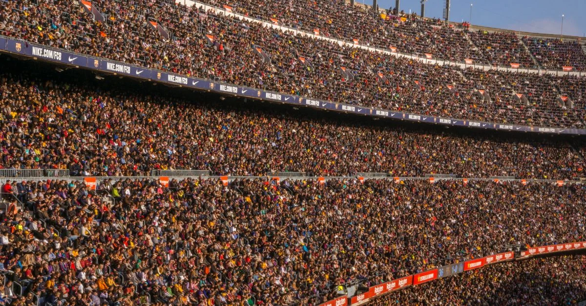 Una multitud vibrante llena el estadio Camp Nou, Barcelona durante un partido de fútbol.