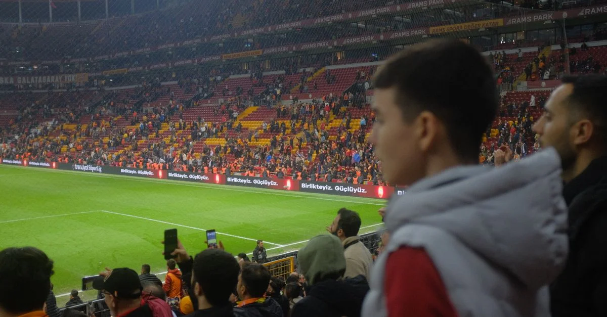Multitud en un emocionante partido de fútbol en el estadio de Estambul con una atmósfera vibrante.