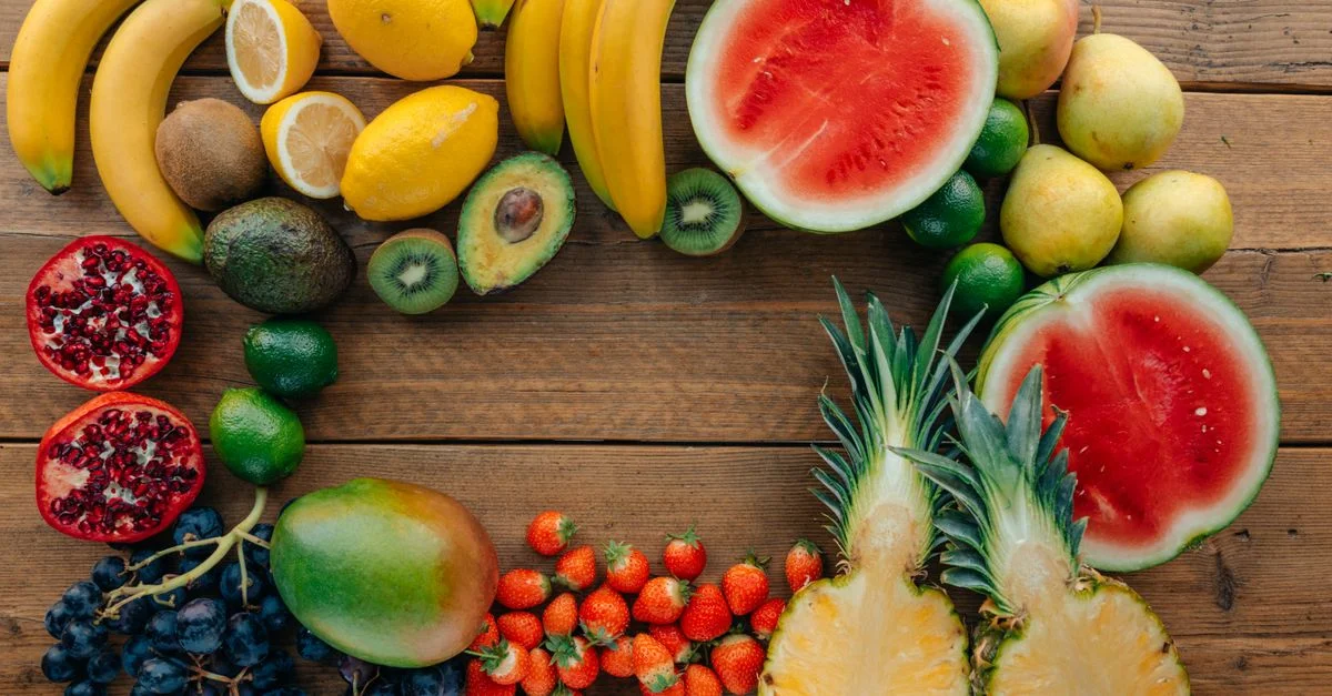 Colorida variedad de frutas frescas en una disposición sobre una superficie de madera, perfecta para temas de estilo de vida saludable.