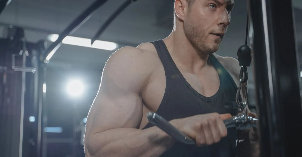 Un hombre concentrado haciendo ejercicio en un gimnasio, mostrando fuerza y fitness.
