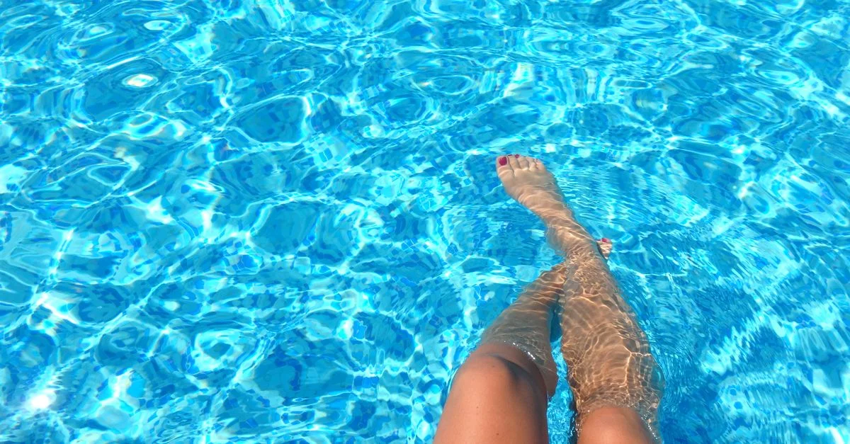 Una persona se relaja en una piscina con agua azul clara, capturando las vibras de verano.